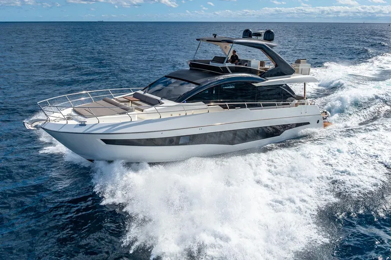  Yacht Photos Pics 2024 Astondoa 66 Flybridge yacht cruising on open sea under clear skies.