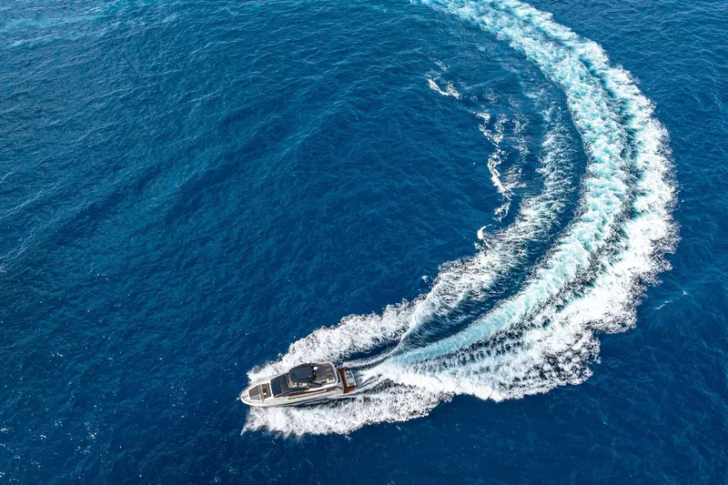  Yacht Photos Pics Aerial view of 2024 Astondoa 66 Flybridge yacht cruising in blue ocean waters.