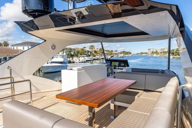  Yacht Photos Pics Luxurious 2024 Astondoa 66 Flybridge yacht with elegant outdoor seating and scenic waterfront view.