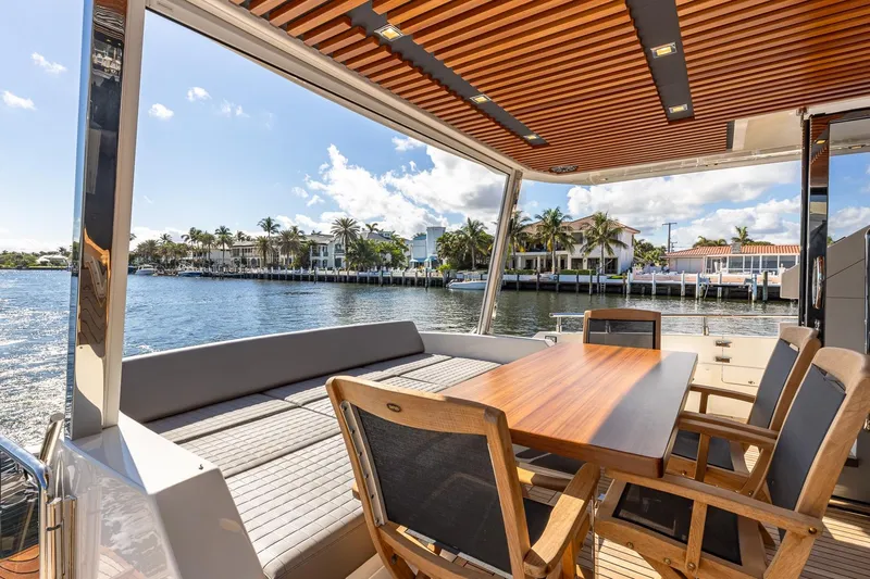  Yacht Photos Pics 2024 Astondoa 66 Flybridge yacht with elegant outdoor seating and waterfront view.