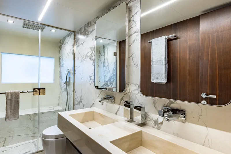 Yacht Photos Pics Luxurious bathroom in 2024 Astondoa 66 Flybridge yacht, featuring marble and wood accents.