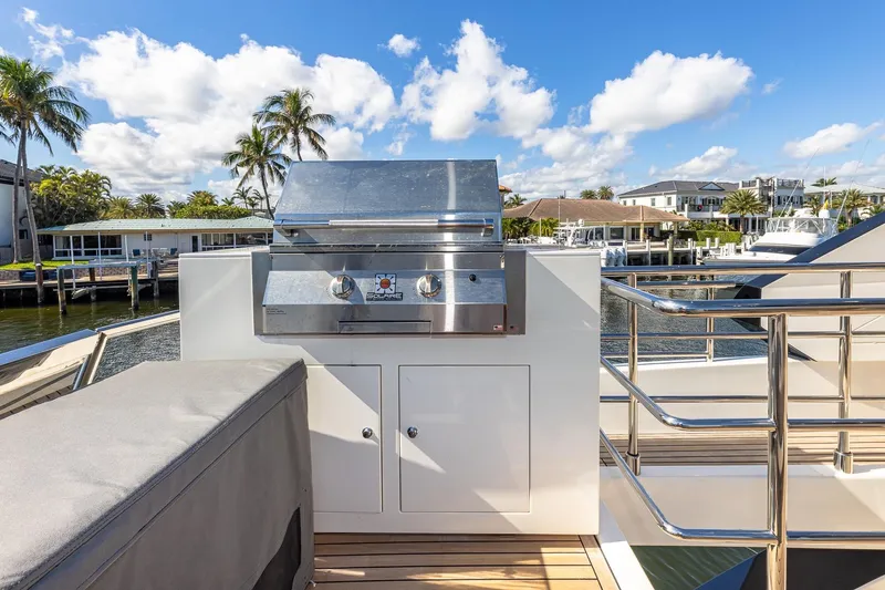  Yacht Photos Pics Outdoor grill on 2024 Astondoa 66 Flybridge yacht, docked with scenic waterfront view.
