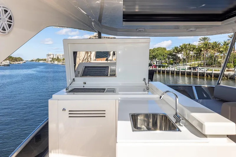  Yacht Photos Pics 2024 Astondoa 66 Flybridge yacht with outdoor kitchen and scenic waterfront view.