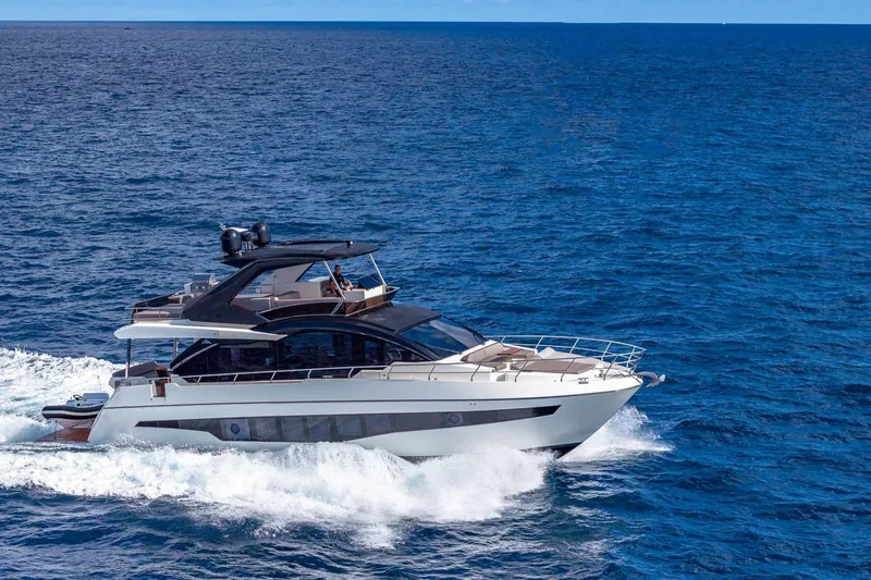  Yacht Photos Pics 2024 Astondoa 66 Flybridge yacht cruising on open sea, showcasing luxury design.