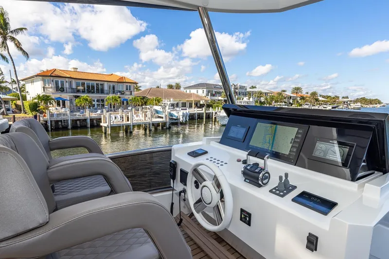  Yacht Photos Pics 2024 Astondoa 66 Flybridge yacht helm with modern controls and waterfront view.