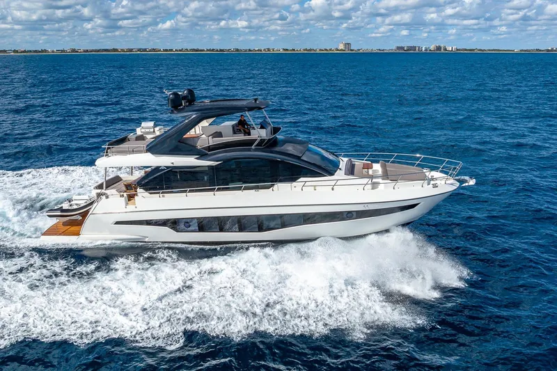  Yacht Photos Pics 2024 Astondoa 66 Flybridge yacht cruising on open sea under blue sky.