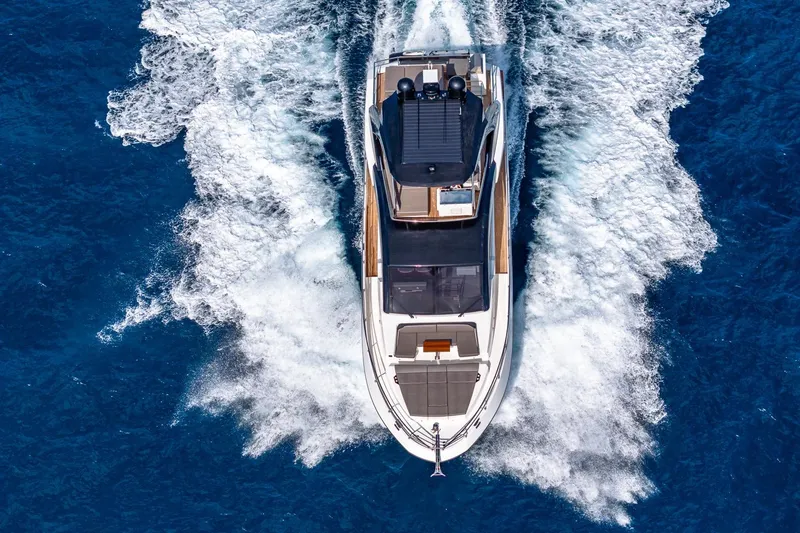  Yacht Photos Pics Aerial view of 2024 Astondoa 66 Flybridge yacht cruising on blue ocean waters.