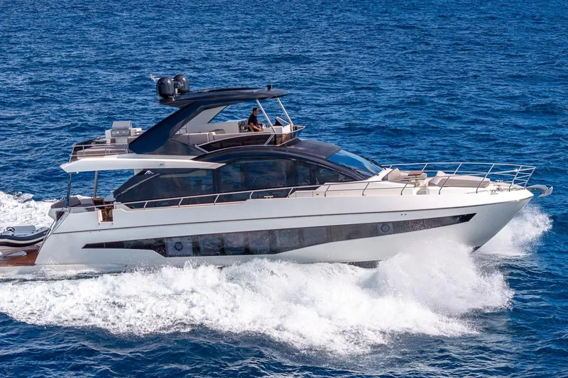  Yacht Photos Pics 2024 Astondoa 66 Flybridge yacht cruising on open sea, showcasing sleek design.