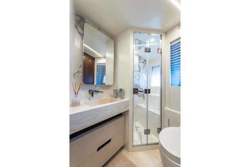  Yacht Photos Pics Luxurious bathroom in 2024 Astondoa 66 Flybridge yacht with marble accents and modern fixtures.