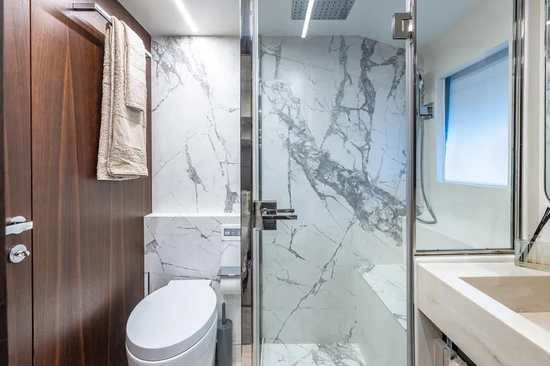 Yacht Photos Pics Luxurious bathroom in 2024 Astondoa 66 Flybridge yacht with marble shower and modern fixtures.