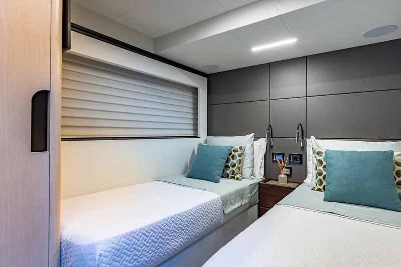  Yacht Photos Pics Luxurious twin cabin in 2024 Astondoa 66 Flybridge yacht, featuring modern decor and cozy bedding.