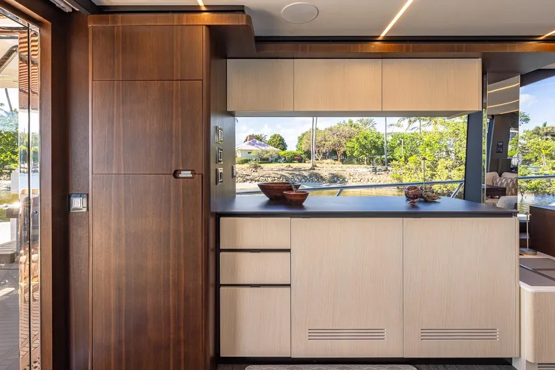  Yacht Photos Pics Luxurious interior of 2024 Astondoa 66 Flybridge yacht with modern cabinetry and scenic window view.