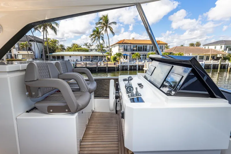 Yacht Photos Pics 2024 Astondoa 66 Flybridge helm with luxurious seating and waterfront view.