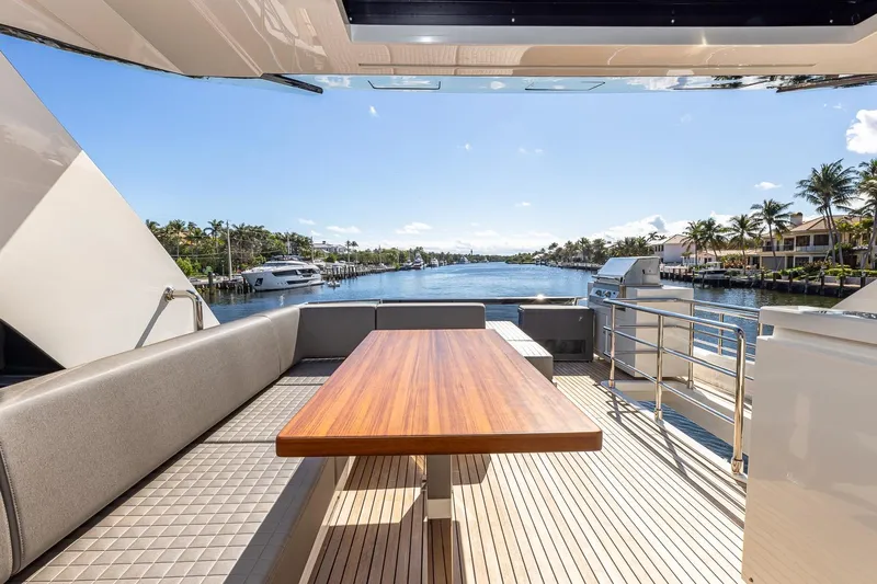  Yacht Photos Pics 2024 Astondoa 66 Flybridge yacht deck with elegant seating and scenic waterfront view.