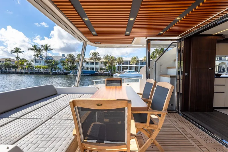  Yacht Photos Pics Luxurious 2024 Astondoa 66 Flybridge yacht with elegant outdoor seating and scenic waterfront view.