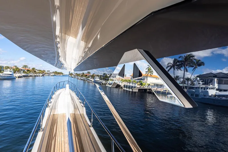  Yacht Photos Pics 2024 Astondoa 66 Flybridge yacht cruising on a sunny waterfront with palm trees.