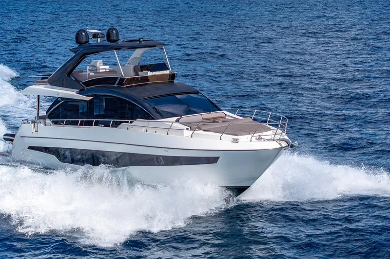  Yacht Photos Pics 2024 Astondoa 66 Flybridge yacht cruising on open water.