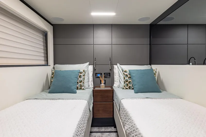  Yacht Photos Pics Twin bedroom in 2024 Astondoa 66 Flybridge yacht, featuring modern decor and cozy bedding.