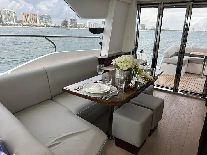 Fairline Squadron Yacht Photos Pics Luxurious interior of 2024 Fairline Squadron 68 yacht with elegant dining setup and sea view.