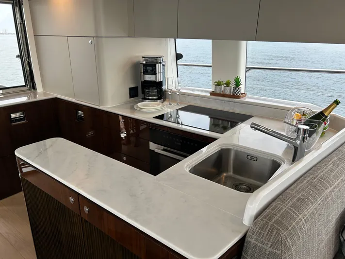 Fairline Squadron Yacht Photos Pics Luxurious kitchen interior of 2024 Fairline Squadron 68 yacht with modern appliances and sea view.