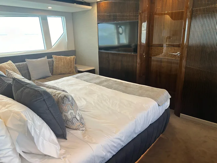 Fairline Squadron Yacht Photos Pics Luxurious bedroom interior of 2024 Fairline Squadron 68 yacht with modern decor and large window.