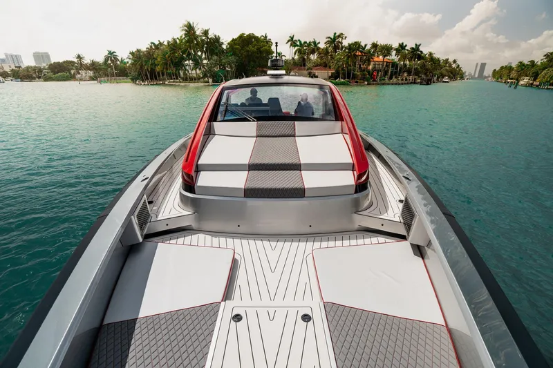 Mana Yacht Photos Pics Luxurious 2025 Maori 54XL yacht cruising on turquoise waters near palm-lined shore.