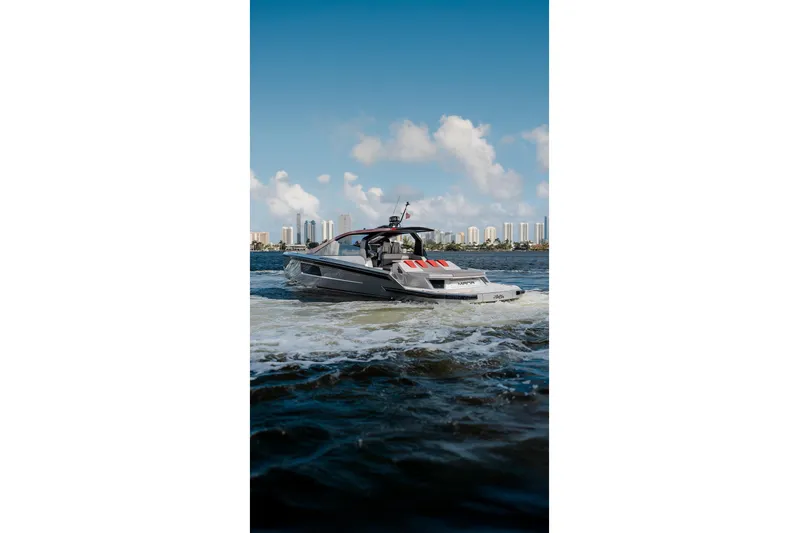 Mana Yacht Photos Pics Luxury Maori 54XL yacht cruising on water, city skyline in background, 2025 model.