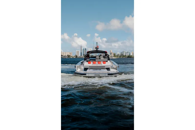 Mana Yacht Photos Pics Luxury Maori 54XL yacht cruising on water, city skyline in background, 2025 model.