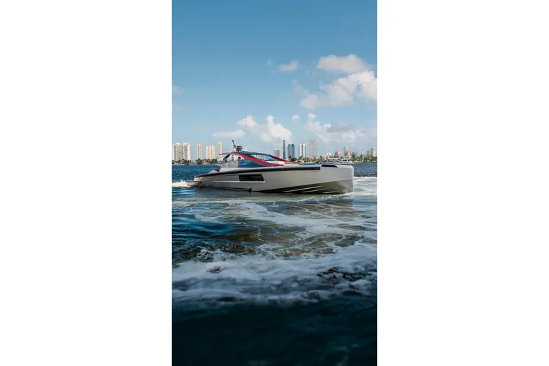 Mana Yacht Photos Pics Luxury Maori 54XL yacht cruising on water, city skyline in background, 2025 model.