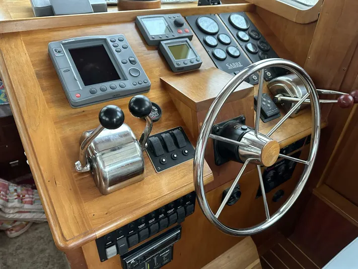 Blue Goose Yacht Photos Pics Control panel of 2003 Sabre 36 Fly Bridge Sedan with steering wheel and navigation instruments.