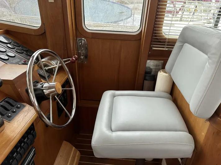 Blue Goose Yacht Photos Pics 2003 Sabre 36 Fly Bridge Sedan helm with steering wheel and cushioned seat.