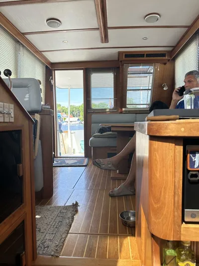 Blue Goose Yacht Photos Pics Interior of 2003 Sabre 36 Fly Bridge Sedan with wood finish and seated person.