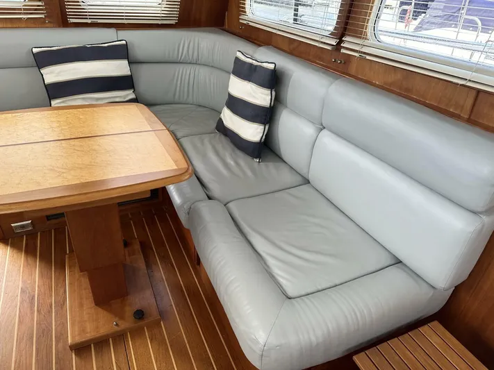 Blue Goose Yacht Photos Pics 2003 Sabre 36 Fly Bridge Sedan interior with gray leather seating and wooden table.