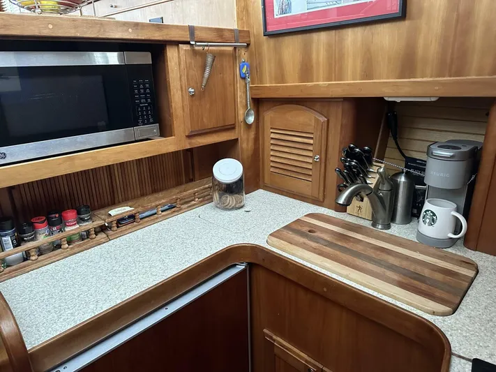 Blue Goose Yacht Photos Pics 2003 Sabre 36 Fly Bridge Sedan kitchen with microwave, cutting board, and coffee maker.