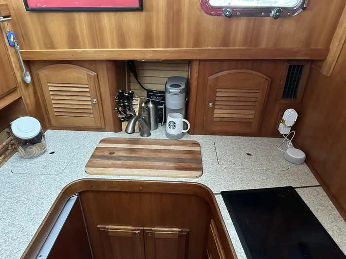 Blue Goose Yacht Photos Pics Galley kitchen in 2003 Sabre 36 Fly Bridge Sedan with wooden cabinets and countertop appliances.