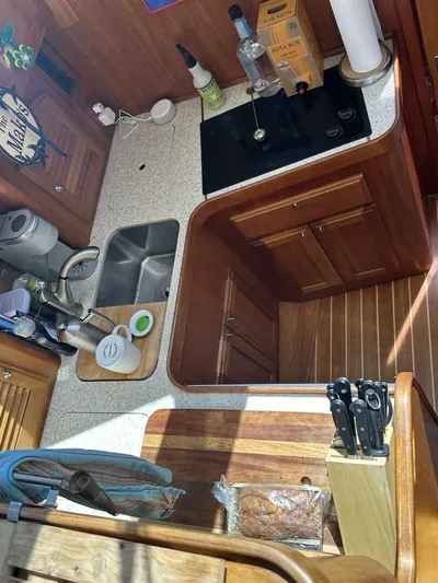 Blue Goose Yacht Photos Pics 2003 Sabre 36 Fly Bridge Sedan kitchen with sink, stove, and wooden cabinetry.