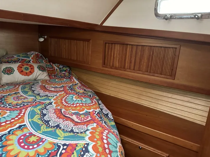 Blue Goose Yacht Photos Pics Cozy cabin interior of 2003 Sabre 36 Fly Bridge Sedan with colorful bedding and wooden accents.