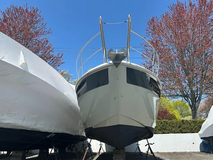  Yacht Photos Pics 2017 Bavaria S36 Coupe boat on land, surrounded by trees and other boats.