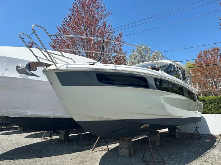  Yacht Photos Pics 2017 Bavaria S36 Coupe boat on stands, surrounded by trees and clear blue sky.