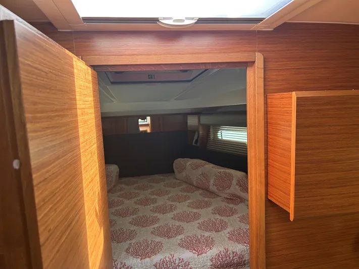  Yacht Photos Pics 2017 Bavaria S36 Coupe cabin with wooden interior and patterned bedding.