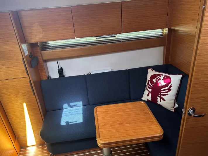  Yacht Photos Pics Interior of 2017 Bavaria S36 Coupe with blue seating and wooden table.