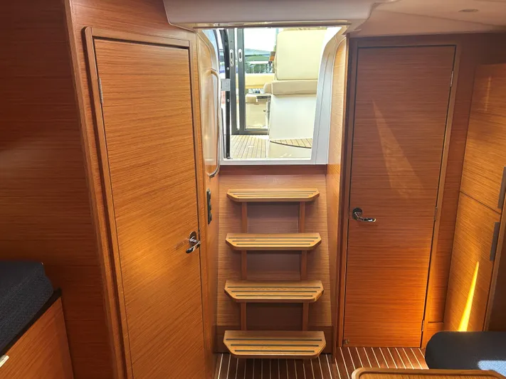  Yacht Photos Pics Interior of 2017 Bavaria S36 Coupe yacht with wooden finish and steps leading outside.