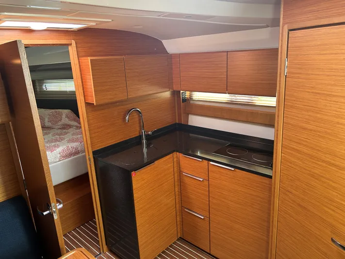  Yacht Photos Pics Modern kitchen interior of 2017 Bavaria S36 Coupe yacht with wood finish and compact design.