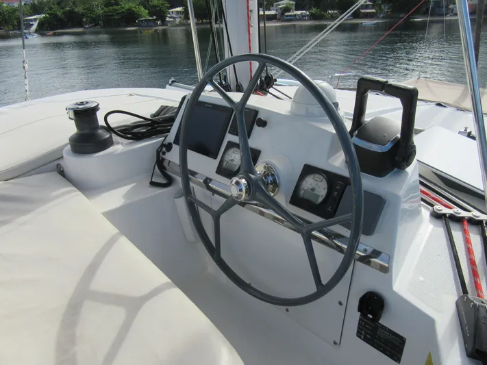 Lady Ana Yacht Photos Pics Steering wheel and controls of a 2020 Bali 4.1 catamaran, docked by a serene waterfront.