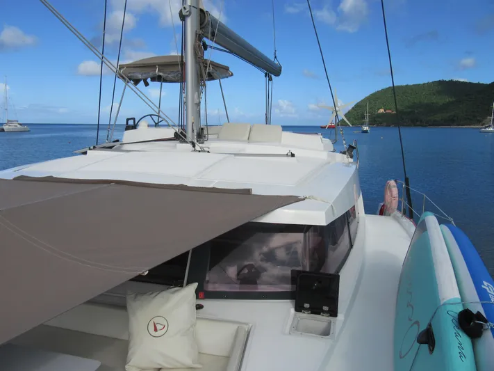 Lady Ana Yacht Photos Pics Bali 4.1 catamaran on calm waters, featuring a sunshade and paddleboard, 2020 model.