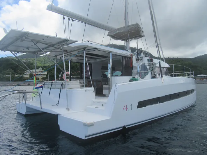 Lady Ana Yacht Photos Pics 2020 Bali 4.1 catamaran anchored near lush coastline under cloudy sky.