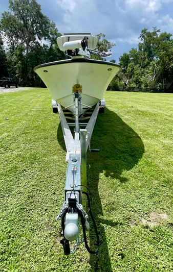  Yacht Photos Pics 2021 Orion 29CC boat on trailer, parked on grassy field under cloudy sky.