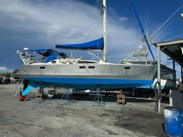 Monica Yacht Photos Pics 2006 Alubat Ovni 395 Centerboard sailboat on stands, blue hull, marina setting.