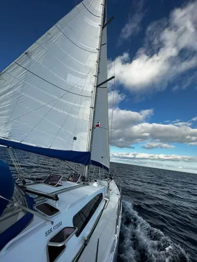 Monica Yacht Photos Pics Sailing yacht Alubat Ovni 395 Centerboard 2006 on open sea under blue sky.