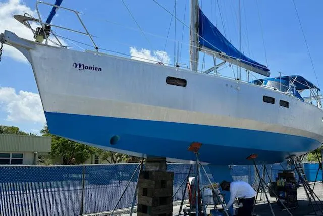 Monica Yacht Photos Pics 2006 Alubat Ovni 395 Centerboard sailboat on land, blue hull, maintenance work underway.